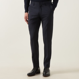 Model wearing Tiger of Sweden dark ink suit trousers with slim fit, styled with black leather Oxford shoes and navy knitwear.