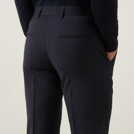 Model wearing Tiger of Sweden Suit Trouser in Dark Ink, rear view showing tailored fit, welt pockets and straight leg cut.
