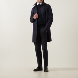 Model wearing Tiger of Sweden Dark Ink suit trousers, styled with a navy overcoat, dark knitwear, white shirt, and black leather shoes.