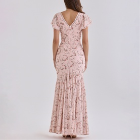 Model wearing House of CB Pink Vintage Rose floral lace maxi dress, flutter sleeves, V-back, fitted mermaid silhouette, shown from behind