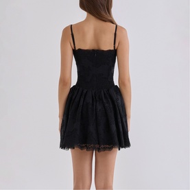 Model wearing House of CB black lace mini dress with spaghetti straps, fitted bodice and full skirt, shown from the back