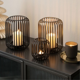 Villeroy & Boch black metal wire lanterns in three sizes with pillar candles, styled on a dark sideboard with decorative accessories