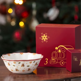Villeroy & Boch festive ceramic bowl with scalloped edge, Christmas motifs, beside red gift box with gold train illustration, Christmas tree backdrop