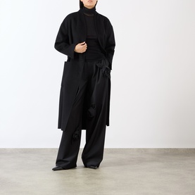 Model wearing MeiMeij Nero T-shirt styled with a long black coat and wide-leg trousers in a head-to-toe black outfit.