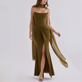 Model wearing House of CB olive maxi dress with halter neck scarf detail, ruched front, thigh-high split, and flowing chiffon overlay