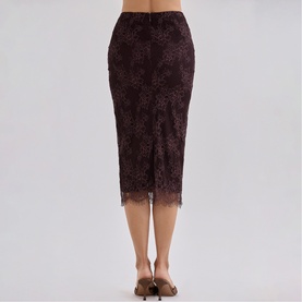 Model wearing House of CB chocolate brown lace midi skirt, back view, styled with nude heeled mules.