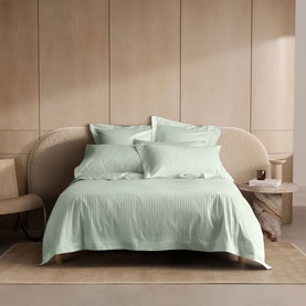 Sheridan light peppermint duvet cover set styled on a bed with matching pillowcases, subtle stripe texture, in a warm neutral bedroom setting.