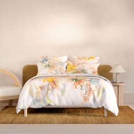 Sheridan white duvet set with multicolour floral print, styled on a double bed with matching pillowcases in a neutral bedroom setting.