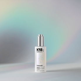 K18 FutureIQ Biomimetic Hair Longevity Serum in a white pump bottle against a soft iridescent pastel background