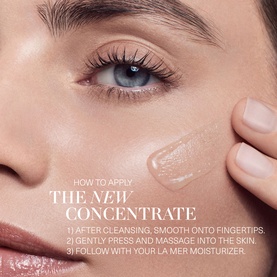 Model with La Mer The Concentrate Serum applied to cheek, demonstrating press and massage application technique on bare skin.
