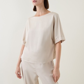 Model wearing FeeG Champagne Top with relaxed silhouette, short sleeves and wide boat neckline, styled with matching wide-leg trousers.