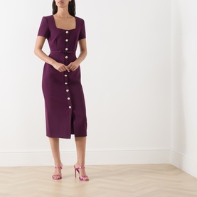 Model wearing FeeG plum midi dress with square neckline, short sleeves, gold button front detail, styled with pink heeled sandals.
