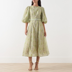 Model wearing FeeG Green Print midi dress with puff sleeves, belted waist and full A-line skirt, styled with gold strappy heels.