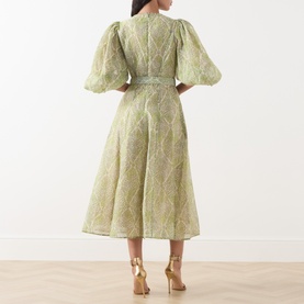 Model wearing FeeG Green Print midi dress, rear view, puff sleeves, belted waist, A-line skirt, styled with gold heeled sandals