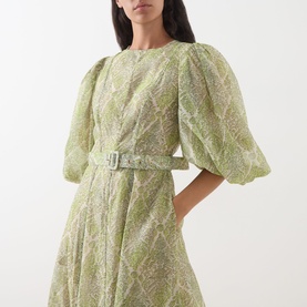 Model wearing FeeG Green Print dress with puff sleeves, floral jacquard fabric, and matching belted waist, styled at midi length.