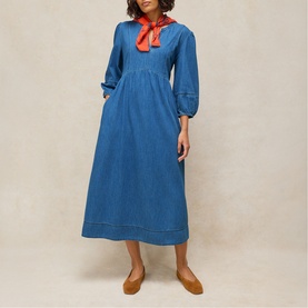 Model wearing White Stuff mid denim midi dress with balloon sleeves and empire waist, styled with red neck scarf and tan flats