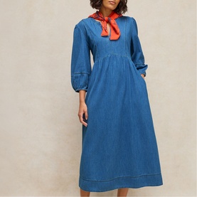 Model wearing White Stuff mid denim midi dress with blouson sleeves and gathered bodice, styled with a red neck scarf.