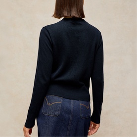 Model wearing White Stuff dark navy fine knit jumper, back view, styled with blue denim jeans