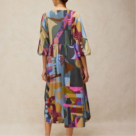 Model wearing White Stuff midi dress in pink multicolour abstract print, flutter sleeves and tiered skirt, back view