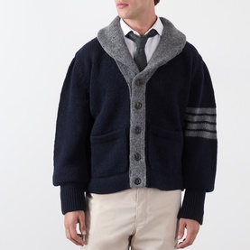 Model wearing Thom Browne navy wool cardigan with grey shawl collar, four-bar stripe detail on sleeve, styled with white shirt and tie