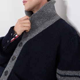 Model wearing Thom Browne navy wool cardigan with grey contrast collar, stripe trim detail, and button front fastening.