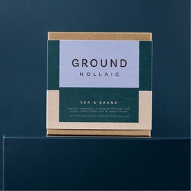 Ground Wellbeing Nollaig Sea & Sauna bodycare gift set in kraft and dark green box, displayed on teal surface