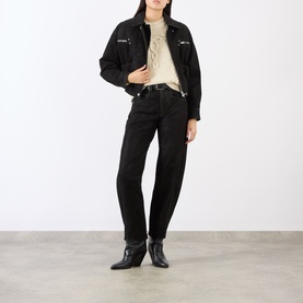 Model wearing Isabel Marant Etoile black jeans, styled with a matching black denim jacket and black ankle boots.