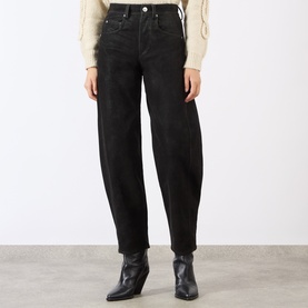 Model wearing Isabel Marant Etoile black barrel-leg jeans, styled with a cream knit top and black ankle boots.