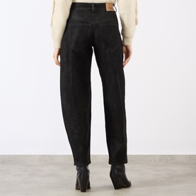 Model wearing Isabel Marant Etoile black barrel-leg jeans, rear view, styled with cream knit and black ankle boots.