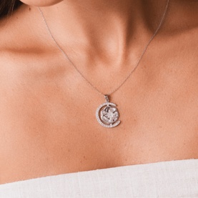 Model with Mettle & Bloom silver circular pendant necklace featuring crystal embellishments, worn on a fine silver chain