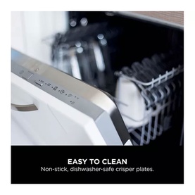 Close-up of non-stick, dishwasher-safe crisper plates loaded in a dishwasher rack, highlighting easy-clean feature.