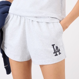 Model wearing Sporty and Rich Heather Gray Navy shorts with LA Dodgers logo, styled with a matching gray top and navy jacket.