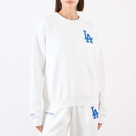 Model wearing Sporty and Rich White Team Blue LA sweatshirt with matching white joggers. Blue LA logo on chest and sleeve.