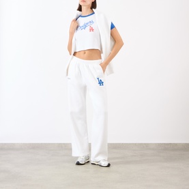 Model wearing Sporty and Rich White Team Blue LA Dodgers sweat bottoms with matching cropped tee and white trainers.