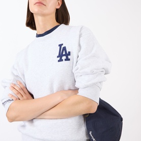 Model wearing Sporty and Rich Heather Gray Navy LA sweatshirt, styled with a navy crossbody bag.