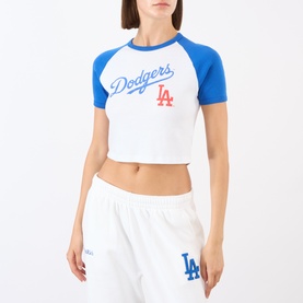 Model wearing Sporty and Rich white and blue cropped Dodgers raglan T-shirt, styled with matching white LA-print joggers.