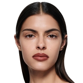 Model wearing Victoria Beckham Lip Definer in a warm terracotta-brown shade, shown in a close-up face shot.