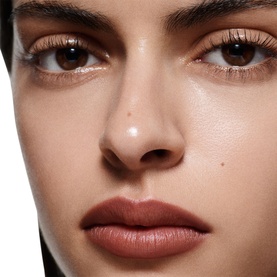 Model with Victoria Beckham Lip Definer worn on lips in a deep mauve-brown shade, shown in a close-up beauty shot