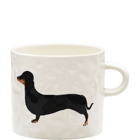 Anna + Nina ceramic mug with embossed dachshund illustration in black and tan on a textured white background, with loop handle.