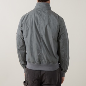 Model wearing Belstaff casual jacket in Atlantic Grey, rear view, ribbed cuffs and hem, zip front, styled with dark trousers