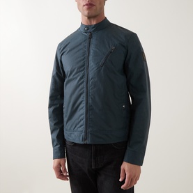 Model wearing Belstaff casual jacket in petrol blue cotton, featuring band collar, zip fastening and chest pocket, styled with black jeans