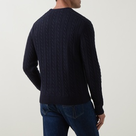 Model wearing Belstaff Dark Ink cable-knit crew neck sweater, rear view, styled with blue denim jeans.
