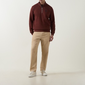 Model wearing Belstaff Oxblood cotton half-zip sweatshirt, styled with beige chinos and white trainers
