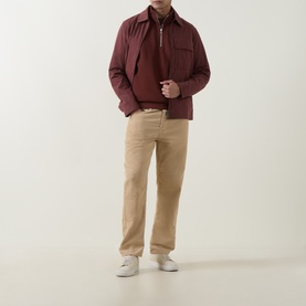 Model wearing Belstaff Oxblood Half Zip with a matching jacket, styled with beige trousers and white trainers.