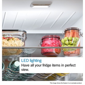 Bosch fridge interior with LED ceiling lighting illuminating shelves stocked with glass food storage containers and fresh vegetables.
