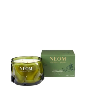 Neom Organics scented candle in dark green glass vessel with three wicks, shown alongside matching green gift box