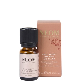 Neom Organics Cosy Nights Essential Oil Blend, small amber glass bottle with black cap beside coral gift box, 10ml