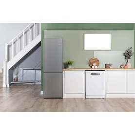 Bosch silver freestanding fridge freezer and white dishwasher in a modern kitchen with green walls and wooden worktop