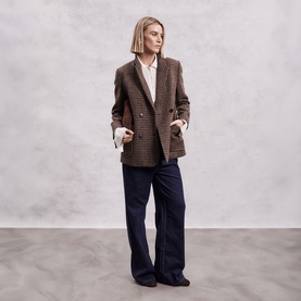 Model wearing The Landskein Lucien Houndstooth Double-Breasted Blazer in Textured Tweed, styled with a white shirt and navy wide-leg trousers