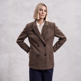 Model wearing The Landskein Lucien Houndstooth Double-Breasted Blazer in Textured Tweed, styled with a white shirt and navy trousers.